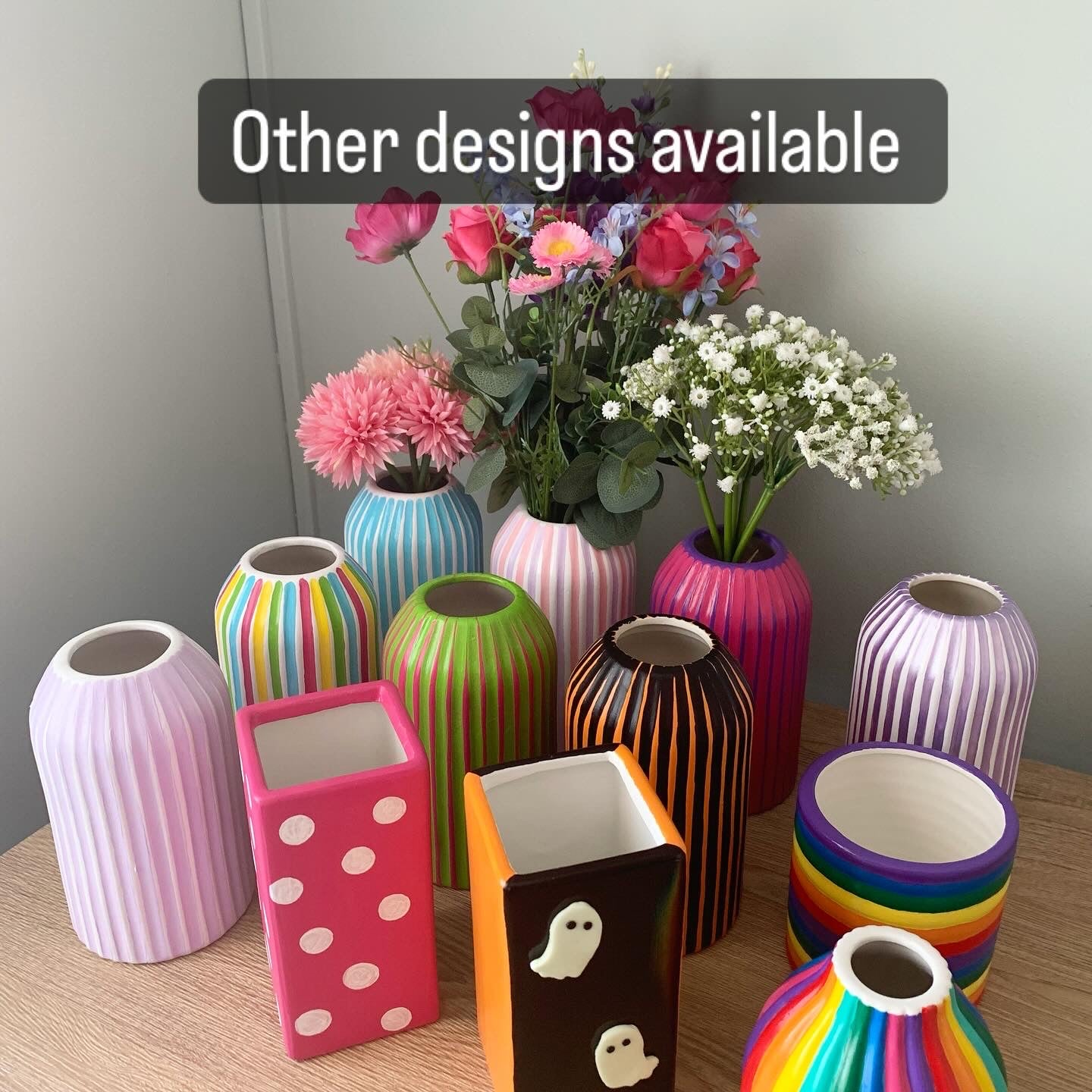 Photo shows a range of other available vases including pink polka dot, rainbow stripes and black and orange stripes
