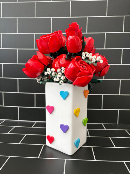 A hand painted white based vase with hand crafted air dried rainbow hearts