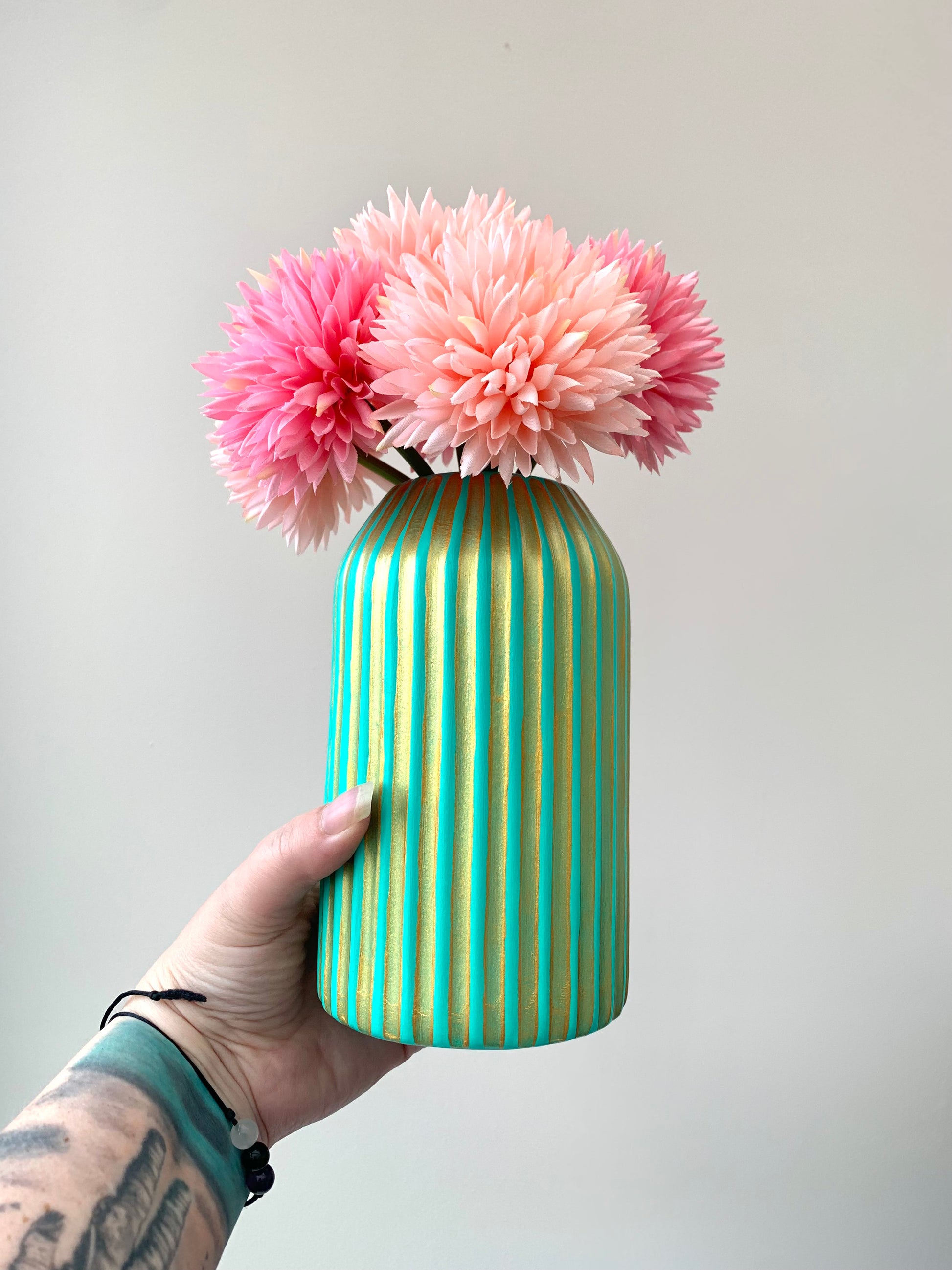 A turquoise and gold hand painted striped vase