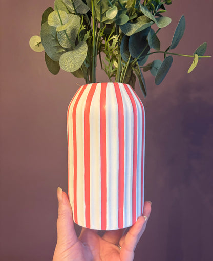 A hand painted white and coral pink striped vase