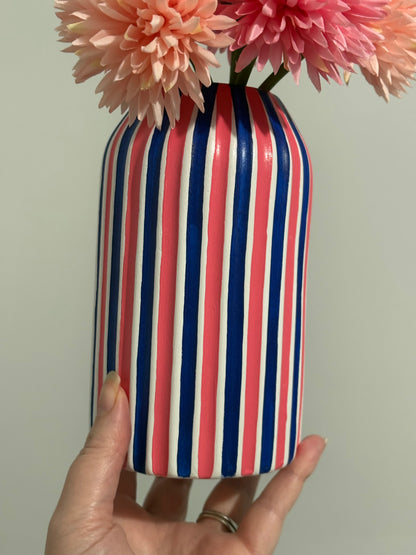 A hand painted white, coral pink and navy blue striped vase